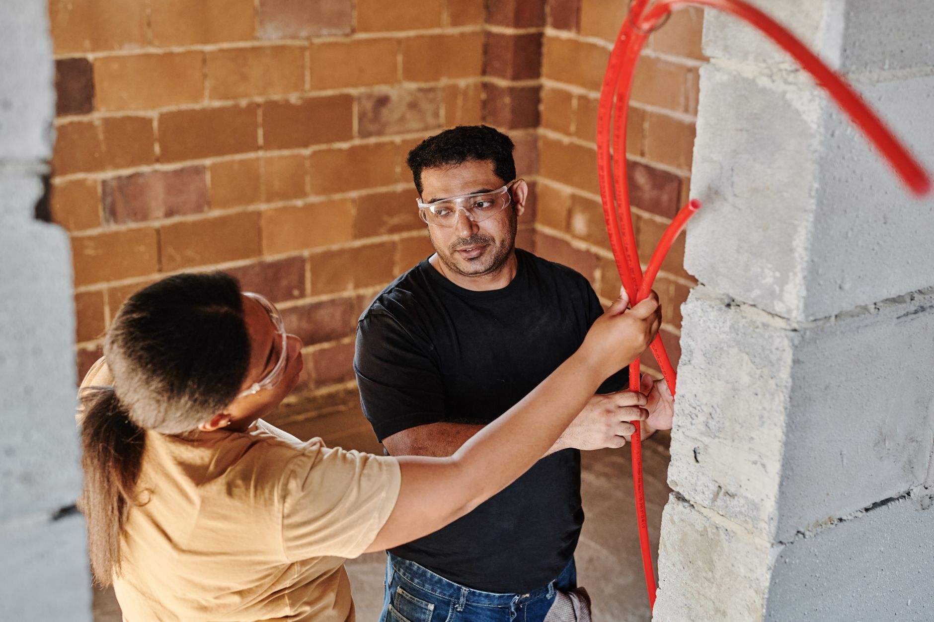 Workers fitting tubing inside a new wall